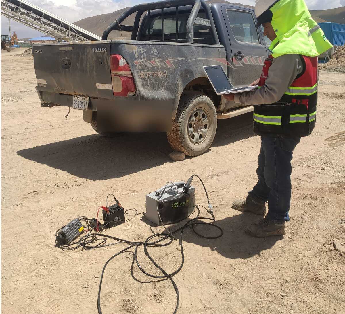 Técnico de LIMASOL con analizador de gases para fuente móvil junto a vehículo en sitio minero
