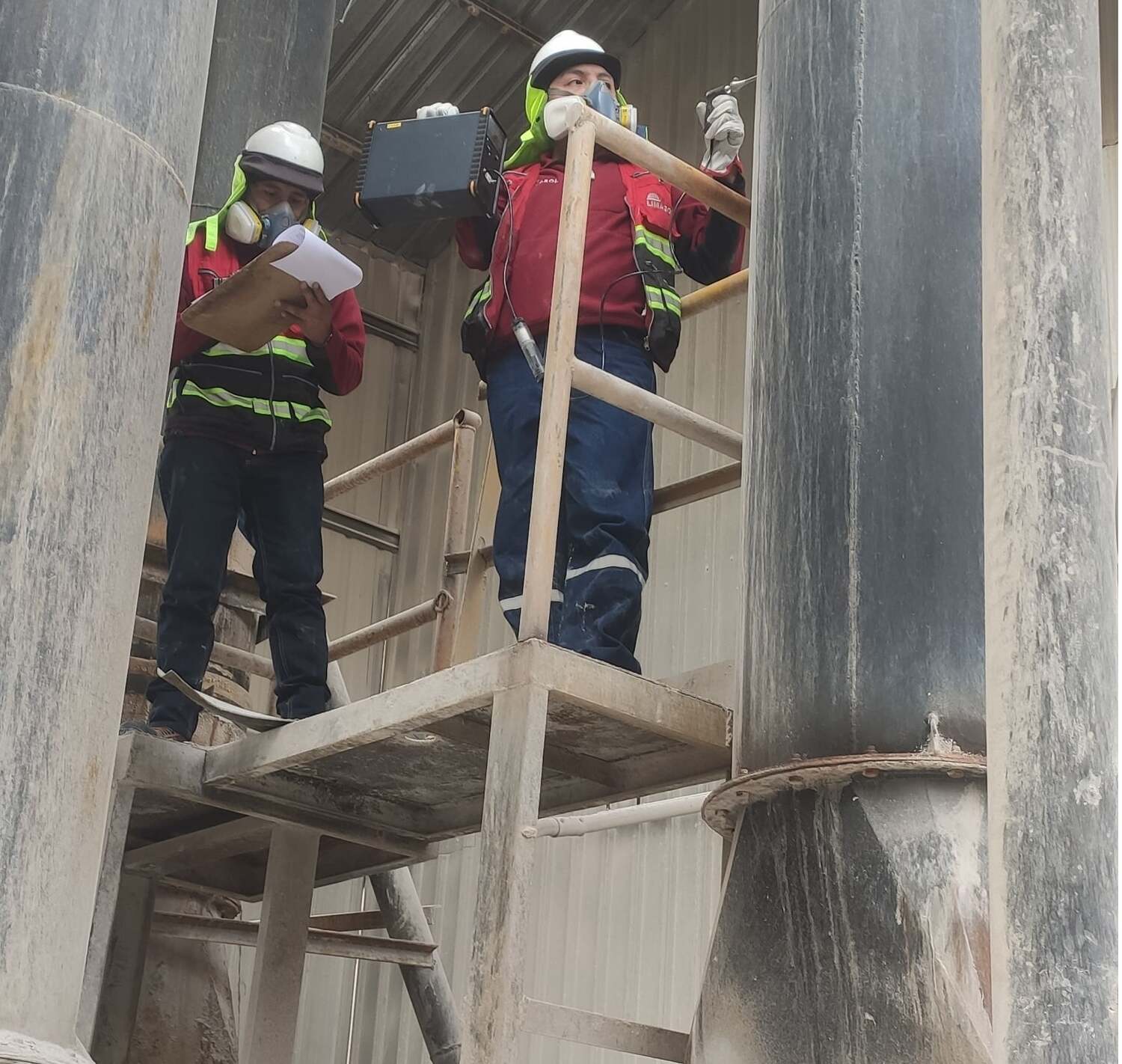 Técnicos de LIMASOL midiendo emisiones en chimenea industrial con analizador multigás