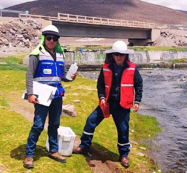 Técnicos de LIMASOL realizando muestreo de agua en campo, junto a un cuerpo de agua
